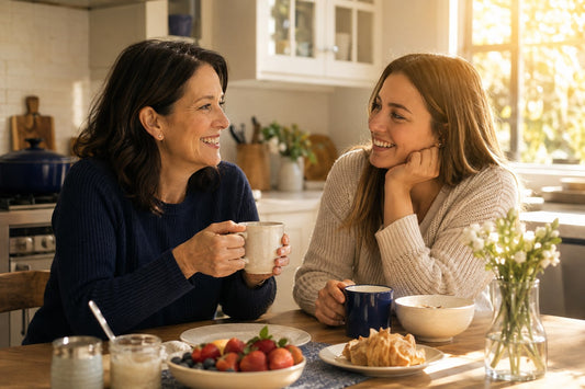 Mother and adult daughter sharing a warm morning conversation at home