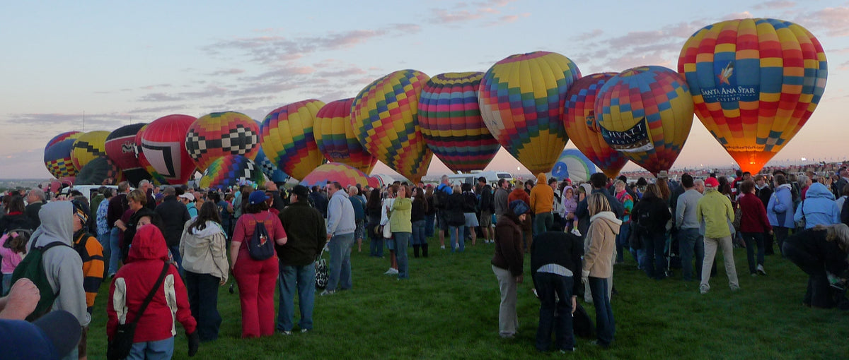 Archive: Balloon Fiesta visitors in jackets beside balloons at dawn in Albuquerque, 2011