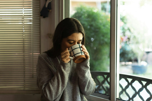 Woman enjoying a calm coffee by the window for National Relaxation Day