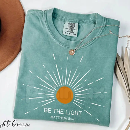 Comfort Colors® "Be The Light" Matthew 5:14 T-Shirt – Aesthetic Bible Verse Shirt, Retro Sunburst Religious Tee, Minimalist Faith-Based Sunlight Top