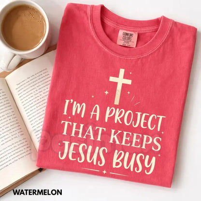 Comfort Colors® "I'm A Project That Keeps Jesus Busy" T-Shirt – Funny Christian Graphic Tee, Sarcastic Faith Humor Shirt, Aesthetic Religious Gift for Her