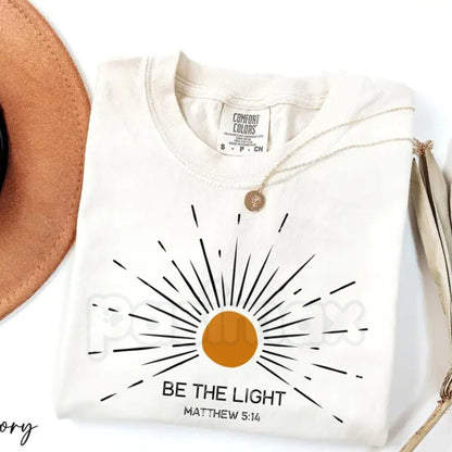 Comfort Colors® "Be The Light" Matthew 5:14 T-Shirt – Aesthetic Bible Verse Shirt, Retro Sunburst Religious Tee, Minimalist Faith-Based Sunlight Top