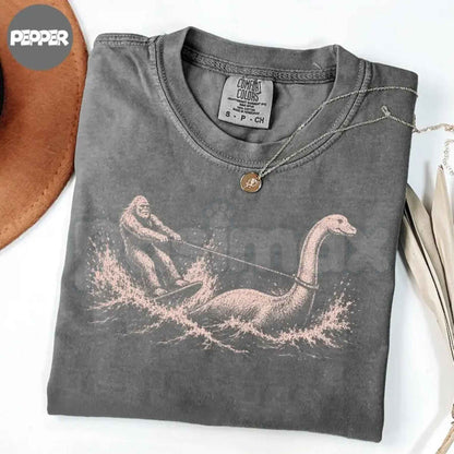 Comfort Colors® Funny Bigfoot & Loch Ness Monster T-Shirt – Retro Cryptid Waterskiing Graphic Tee, Vintage Mythical Creature Lake Life Unisex Top
