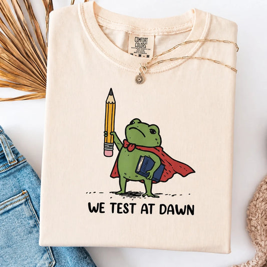 Comfort Colors® "We Test At Dawn" Funny Teacher Frog T-Shirt – Sarcastic Exam Day Graphic Tee, Vintage Testing Season Shirt, Aesthetic Educator Humor Top-Pasimax
